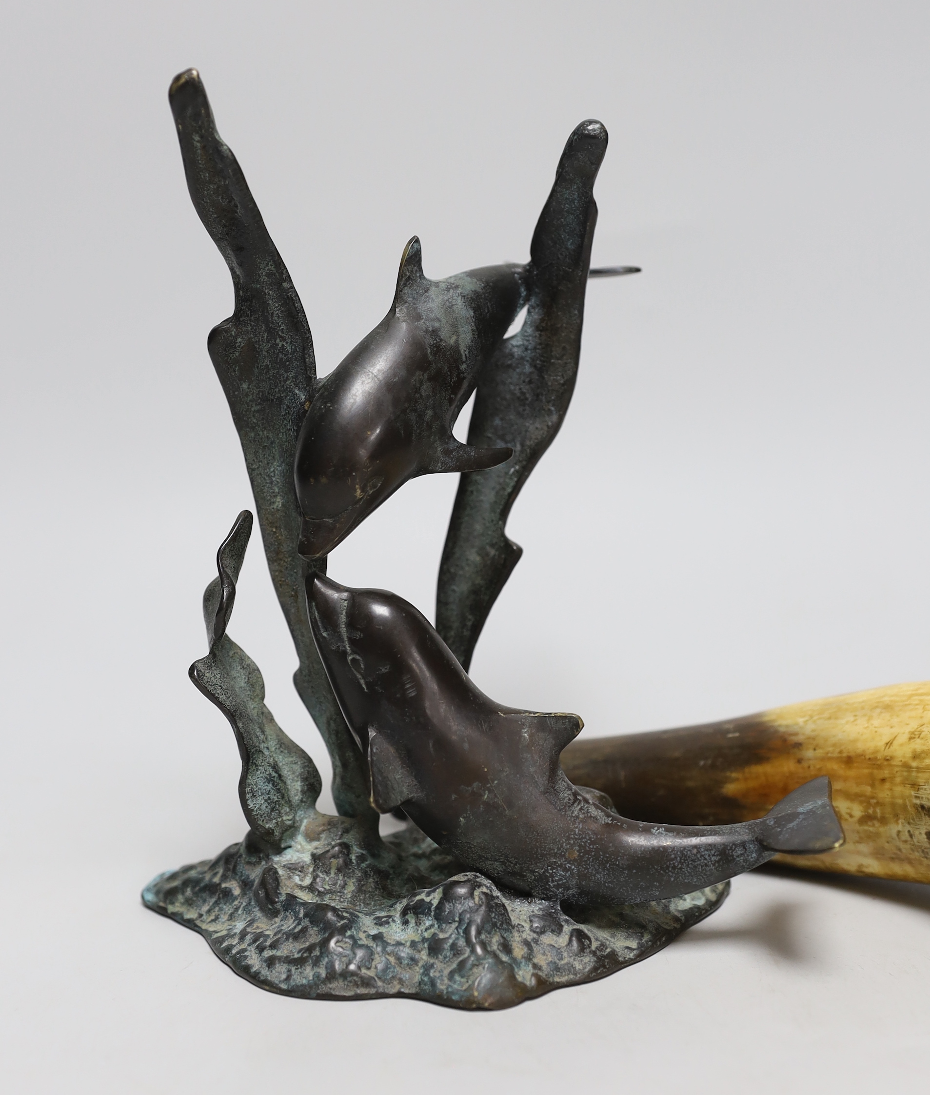 A 19th century powder horn and a cast brass dolphin group, powder horn 23cm long